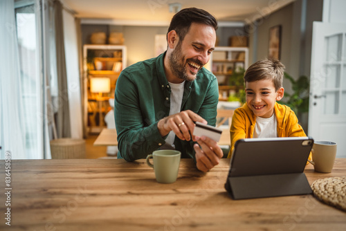 Wallpaper Mural Father and son caucasian buy online with credit card on tablet at home Torontodigital.ca