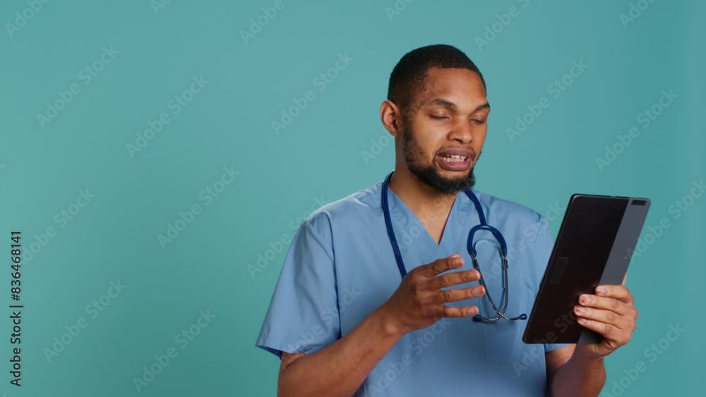 Male nurse in videocall meeting using tablet, greeting people. Healthcare specialist in online telemedicine call with patients, isolated over blue studio background, camera A