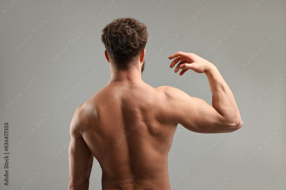 Fototapeta premium Man with muscular body on light grey background, back view