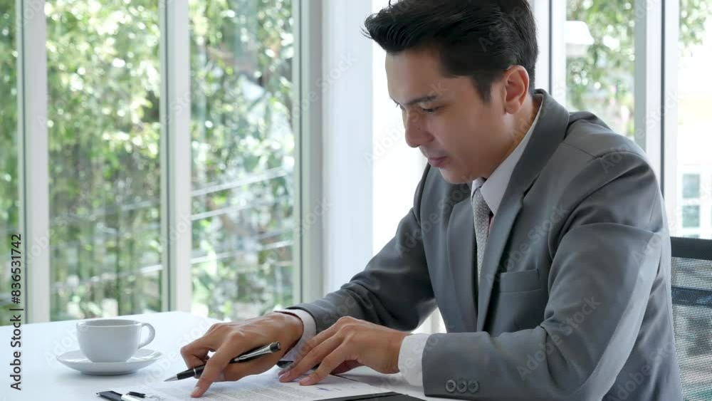 Asian businessman checking document upset disappointed wrong report. Man hands pointing reading paper use pen signing signature writing on agreement. frustrated Businessman manager working in office Asian businessman checking document upset disappointed wrong report. Man hands pointing reading paper use pen signing signature writing on agreement. frustrated Businessman manager working in office