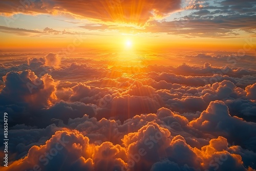 The sun sets over clouds as viewed from an airplane window en route to the nearest island, creating a picturesque scene.






