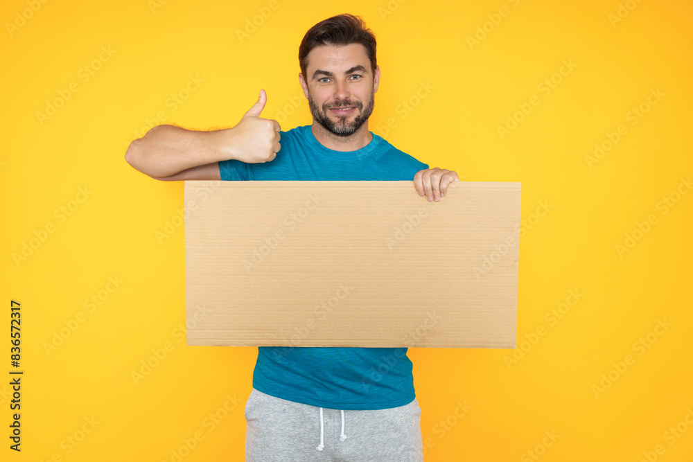 Man with thumb up and blank banner ad, on studio background. Portrait of man holding empty blank poster. Man showing blank poster gesturing thumbs up. Male presenting signboard, billboard or banner. Man with thumb up and blank banner ad, on studio background. Portrait of man holding empty blank poster. Man showing blank poster gesturing thumbs up. Male presenting signboard, billboard or banner.
