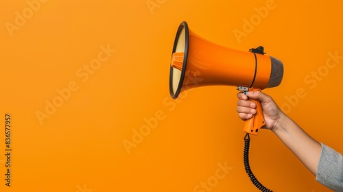 Close-up shot of a hand holding a megaphone with a dynamic pose. Loudspeaker announcement for marketing and sales promotions. 