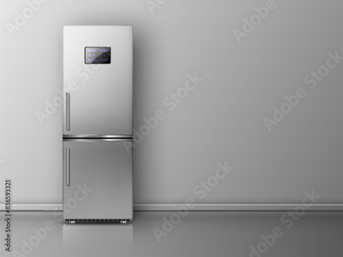 Modern fridge in front of grey wall.