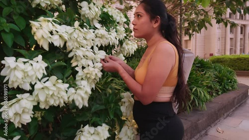 Woman smelling white flowers with yoga mat photo