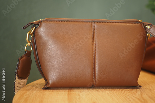 a stylish brown leather handbag on table 