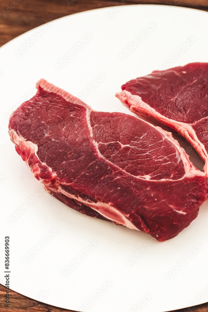 A piece of premium meat, striploin steak on a wooden table A piece of premium meat, striploin steak on a wooden table