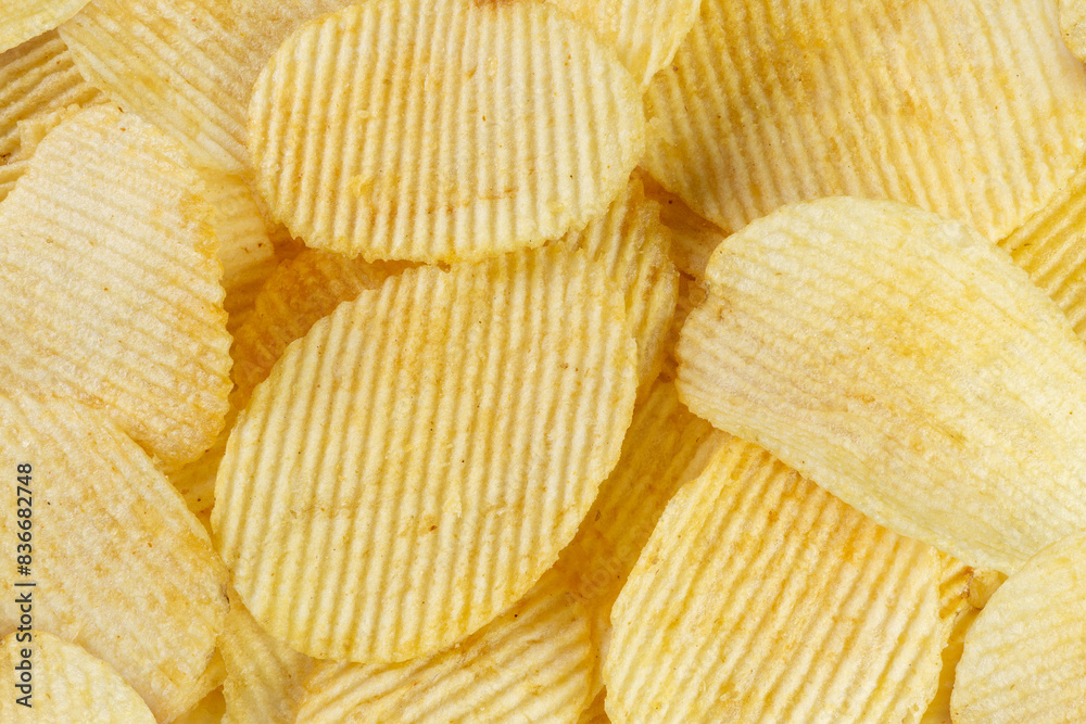 Golden corrugated chips slices with seasoning background