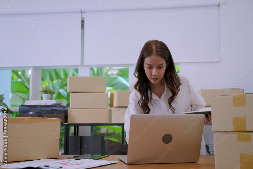 Young female entrepreneur is packing merchandise at home. Young female entrepreneur is packing merchandise at home.