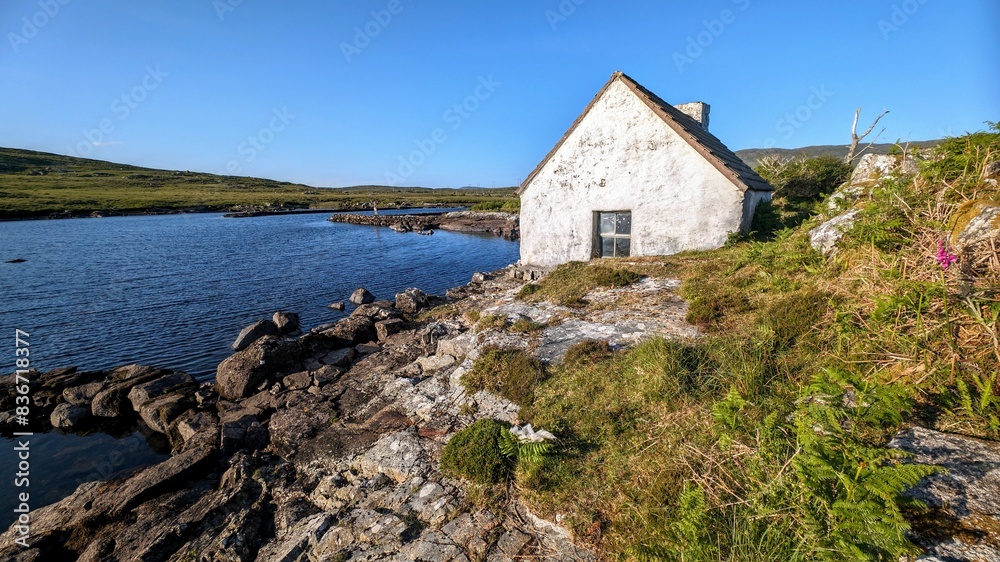 Fisherman hut, cottage on the rocky lakeside coast at Connemara national park, Galway, Ireland