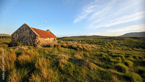 Obraz na płótnie Beautiful landscape scenery with old rusty tin roof cottage on green hill at Connemara National park in County Galway, Ireland w salonie