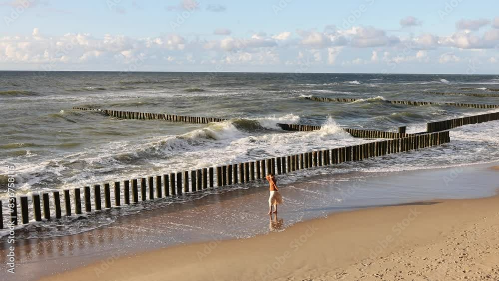 Light waves of the Baltic Sea caress the yellow sand of the coast against the backdrop of white clouds, 4K Light waves of the Baltic Sea caress the yellow sand of the coast against the backdrop of white clouds, 4K