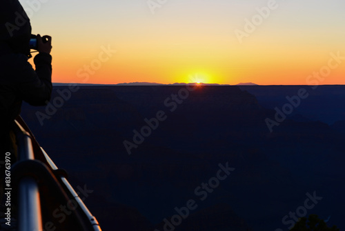 Silhouette image of a tourist taking photos of the Grand Canyon at sunset. Arizona. USA.