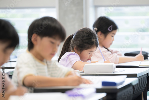 小学校や塾の教室で勉強する小学生の子供たち　テストや試験を受ける