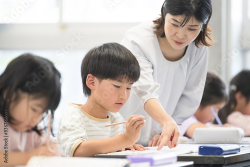 Plakat 学校の教室で勉強する子供たちと指導する先生 クローズアップ