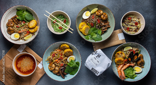 Asian cuisine. Noodles with egg and corn in a plate. On a dark background