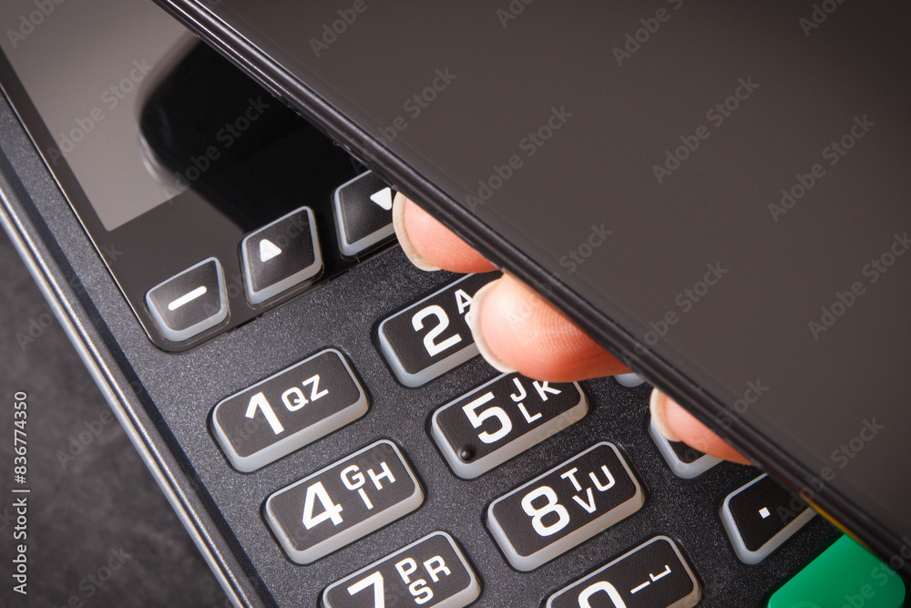Mobile phone or smartphone with payment terminal. Credit card reader. Cashless paying for shopping. Finance concept Mobile phone or smartphone with payment terminal. Credit card reader. Cashless paying for shopping. Finance concept