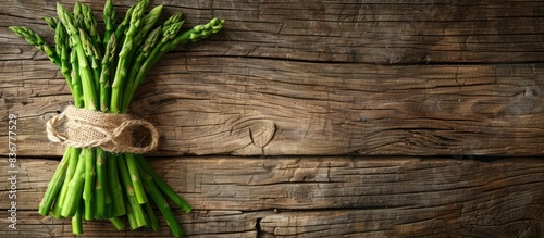 A bunch of fresh green asparagus is neatly arranged on a rustic wooden table showcasing the vibrant colors and textures of this popular vegetable