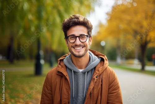 Smiling Young Man in Autumn Park Wearing Glasses and Jacket