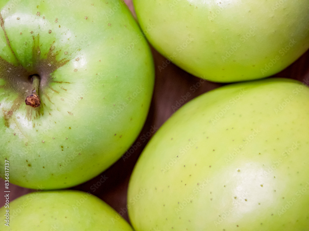 A cluster of ripe green apples, their glossy skins dotted with natural imperfections. A cluster of ripe green apples, their glossy skins dotted with natural imperfections.