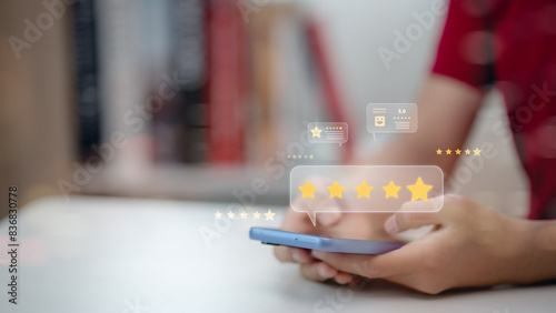 A person is holding a cell phone with a screen displaying a star rating system