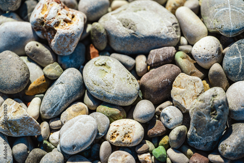 Beach with multicolored small round stones on a sunny day Beach with multicolored small round stones on a sunny day