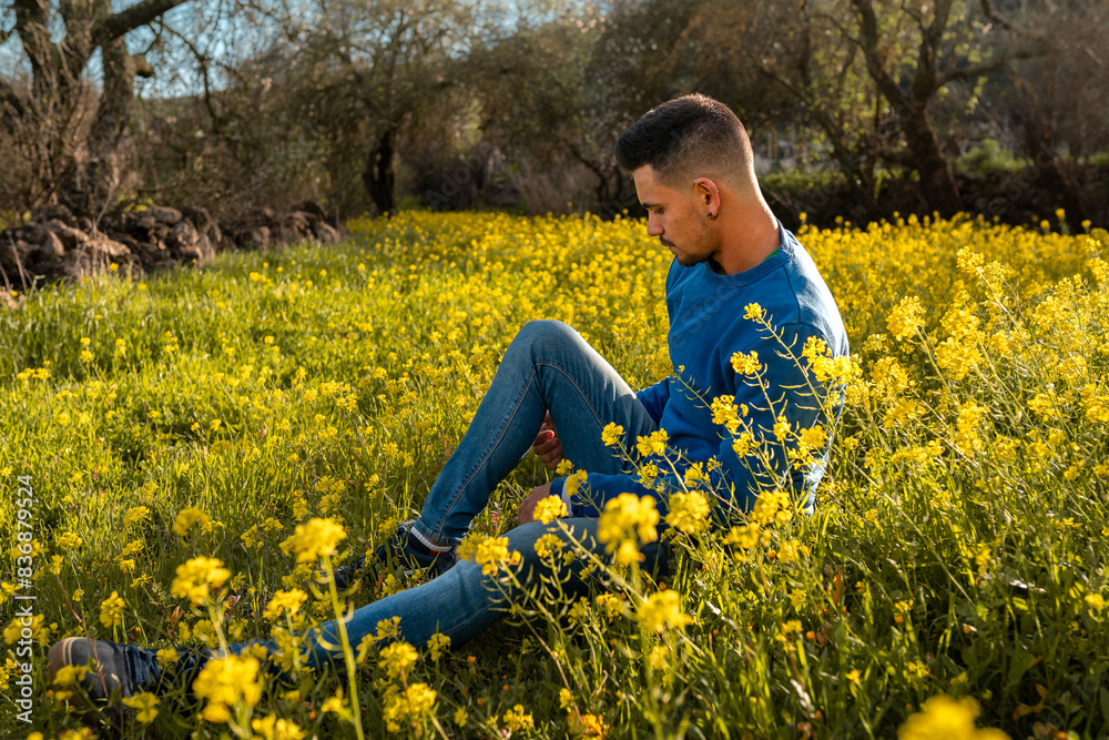 young man in a field of yellow wildflowers at sunset young man in a field of yellow wildflowers at sunset