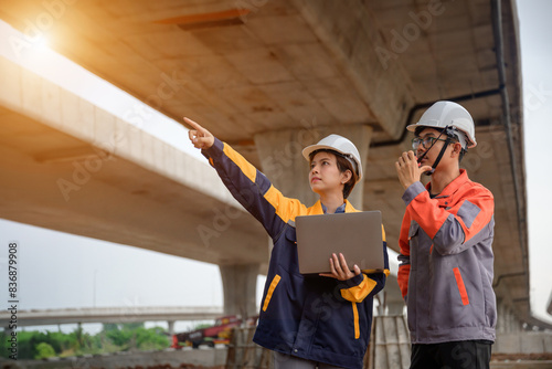 A team of civil engineers collaborates with architects to review designs and oversee the building of a new highway. At the site of highway construction, a male civil engineer and a female architect