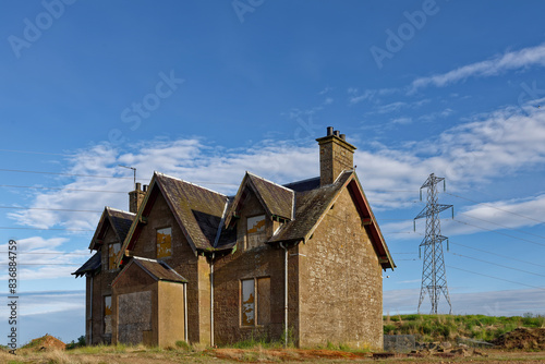 A long abandoned traditional Cottage with the windows and Doors all boarded up overlooking Dean Water Beck near to the market town of Forfar.