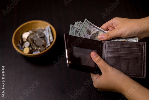 She felt deep sense of fulfillment when donating money to church, placing her tithe of coins and cash into offering bowl, knowing her giving would help fund important causes. donating, money, tithe. photo