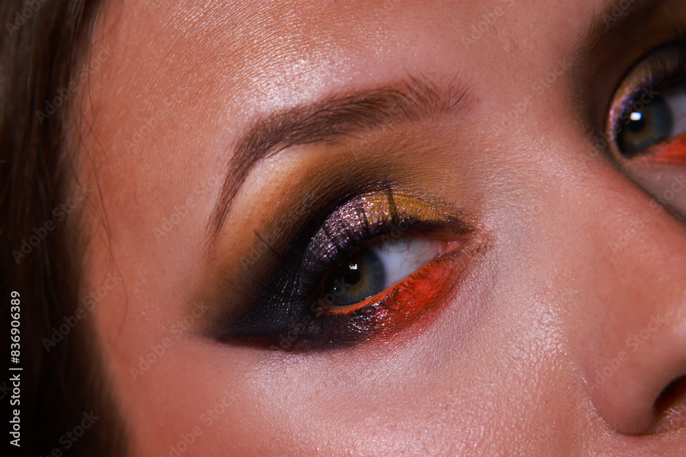 Close up on face with evening arabic dark colorful vibrant eye makeup with doll eyeslahes. Shiny glitter effect with purple, yellow and orange colors Close up on face with evening arabic dark colorful vibrant eye makeup with doll eyeslahes. Shiny glitter effect with purple, yellow and orange colors