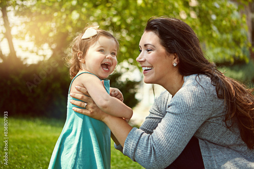 Mother, child and smile with playing in garden for fun activity, bonding or embrace outdoor in home. Happy family, woman or daughter on grass with relax, explore and support with lens flare in nature photo