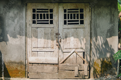 Old vintage door of an Indonesian traditional house made from wood in a village area.