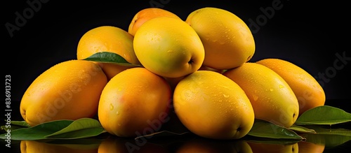 Fresh Beid El Agl mangoes, commonly used in juices, are a large type of edible stone fruit from the Mangifera Indica tree, with a select focus on them in the image. photo