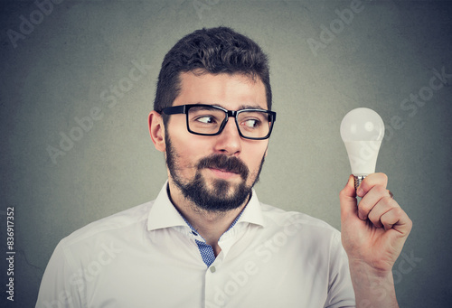 Man looking at an energy efficient light bulb 