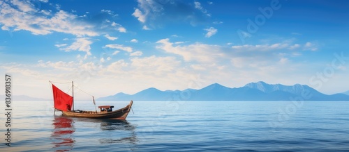 A long tail boat cruising peacefully on the stunning sea with a picturesque view and ample copy space image.