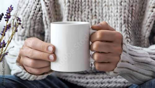 Man holding white mug indoors, closeup. Mockup for design photo