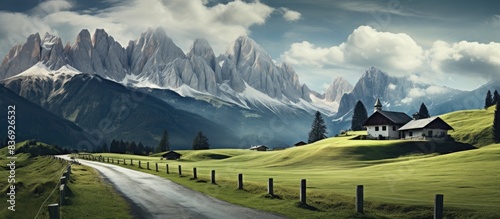 Dolomites form the background of a road leading to a home, with a copy space image available. photo