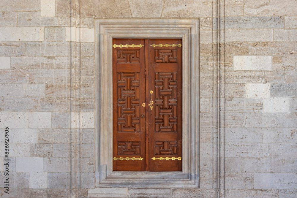 Beyazit mosque located in Beyazıt square. Symmetrical view of the wooden and gold-embroidered window door in the mosque complex from the opposite side. Beyazit mosque located in Beyazıt square. Symmetrical view of the wooden and gold-embroidered window door in the mosque complex from the opposite side.
