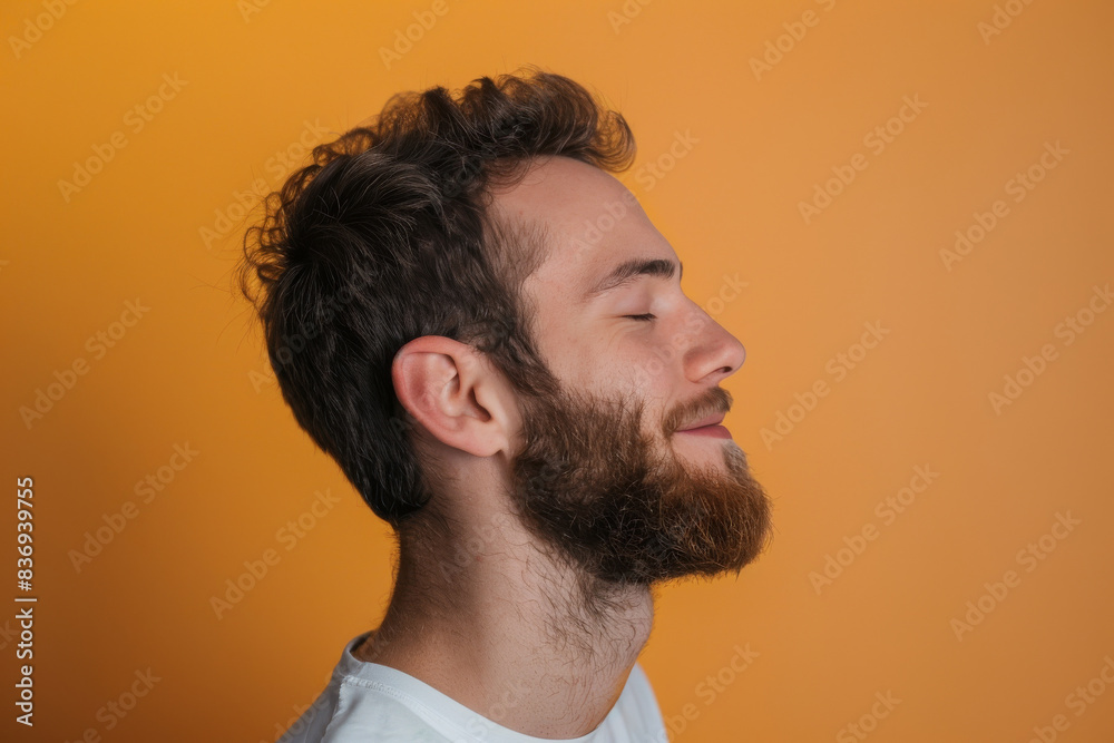 A close up of a man with beard and closed eyes looking to a side A close up of a man with beard and closed eyes looking to a side