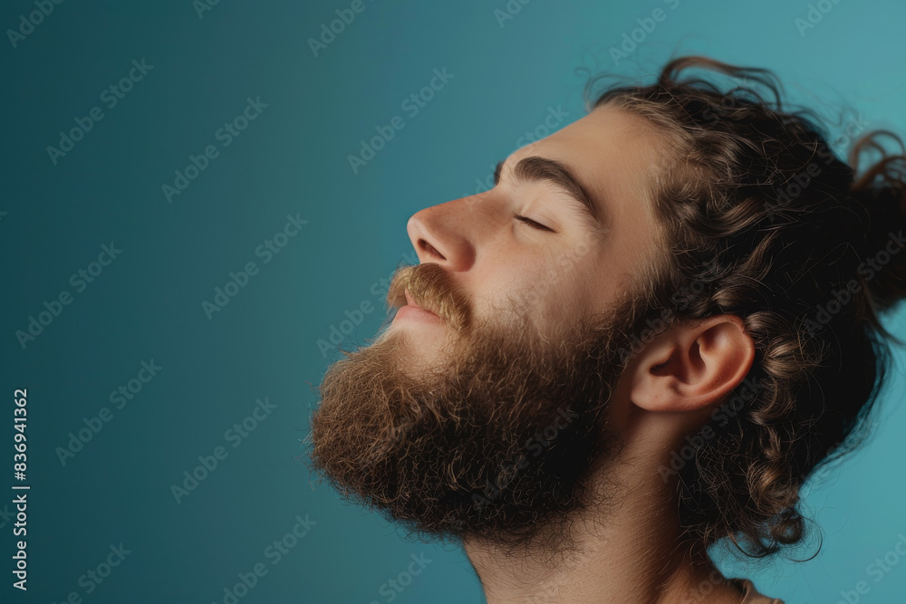 Fototapeta premium A close up of a man with beard and closed eyes looking to a side