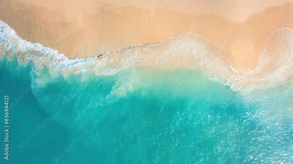 Fototapeta premium bird's eye view of golden sandy shores meeting turquoise ocean waters