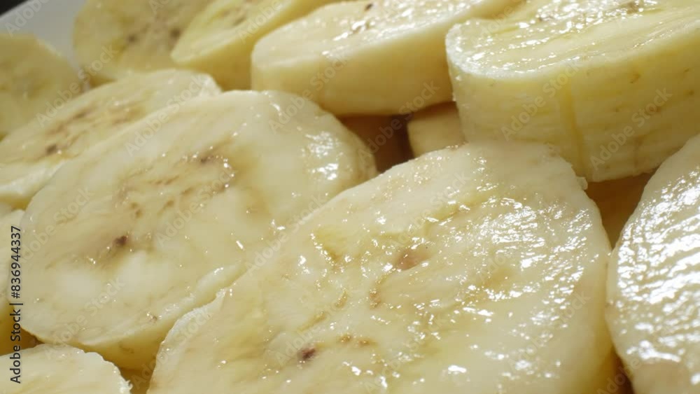 A mesmerizing close-up captures the creamy allure of sliced bananas. Each uniform piece unveils a soft, buttery texture, adorned with delicate brown speckles amidst its gentle yellow hue.
A mesmerizing close-up captures the creamy allure of sliced bananas. Each uniform piece unveils a soft, buttery texture, adorned with delicate brown speckles amidst its gentle yellow hue.