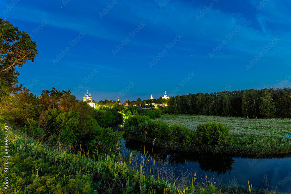 Suzdal, Vladimir region, Russia, Golden Ring - View from the observation deck of the bend of the river and the Church of the Entrance of the Lord to Jerusalem, the Assumption Church and the colonnade Suzdal, Vladimir region, Russia, Golden Ring - View from the observation deck of the bend of the river and the Church of the Entrance of the Lord to Jerusalem, the Assumption Church and the colonnade