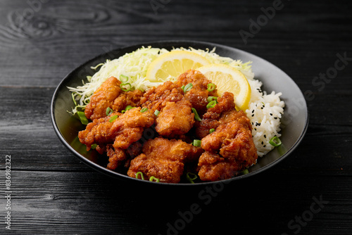 Japanese Fried crispy Chicken Karaage in black bowl with rice and cabbage