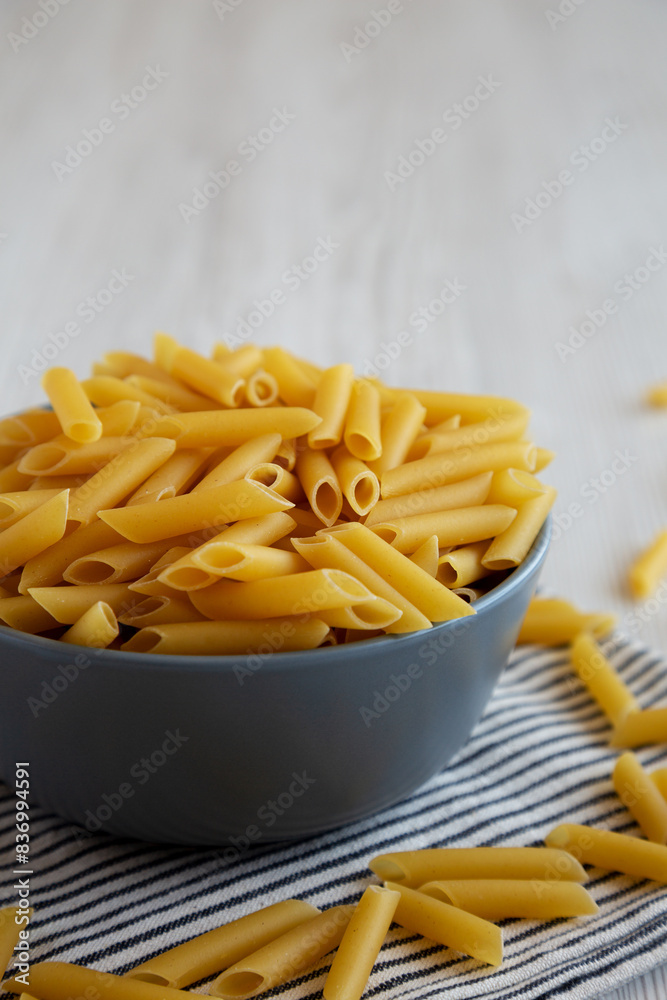 Raw Organic Dry Penne Pasta in a Bowl, side view. Raw Organic Dry Penne Pasta in a Bowl, side view.
