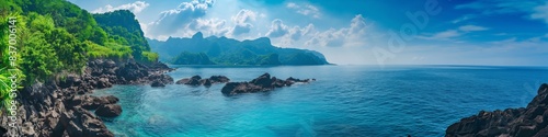 An idyllic view of a rocky coastline with a turquoise lagoon  set against a blue sky and ocean.