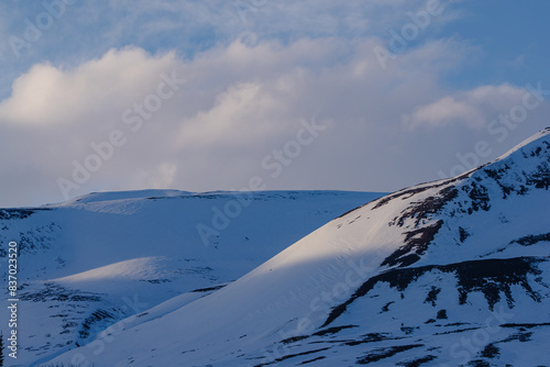 Close-up view of snow-covered mountains under a cloudy sky