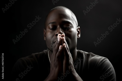 devout african or african american man prays. hands clasped © alisaaa