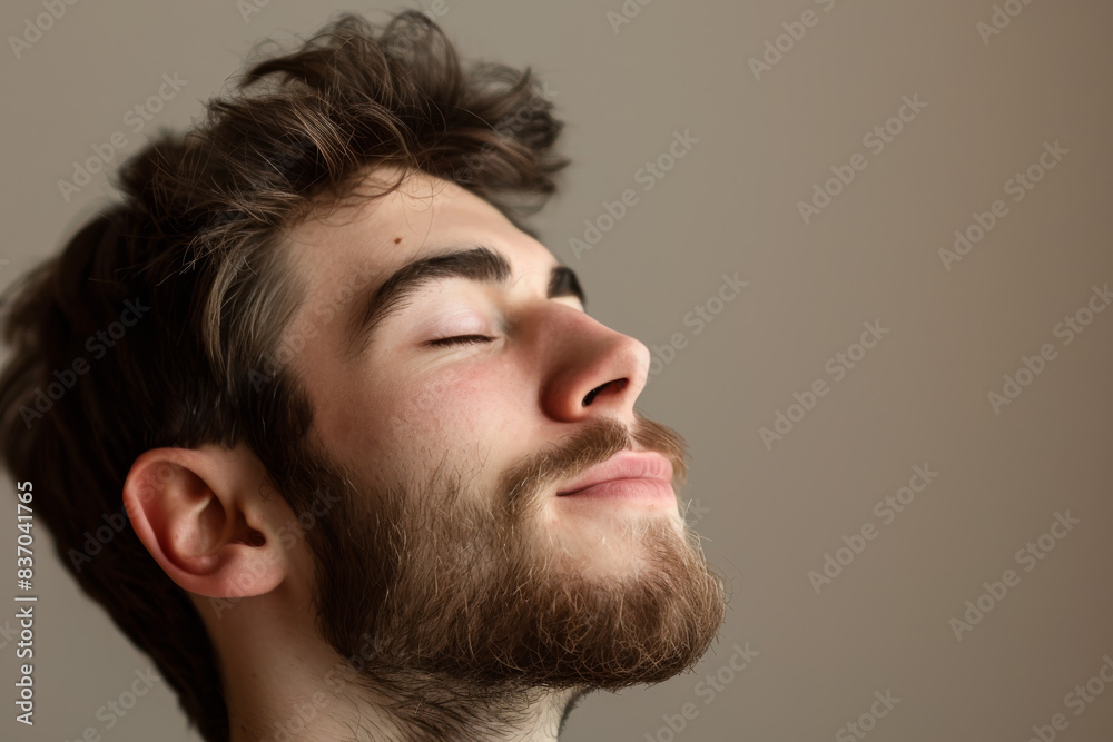 Obraz premium A close up of a man with beard and closed eyes looking to a side